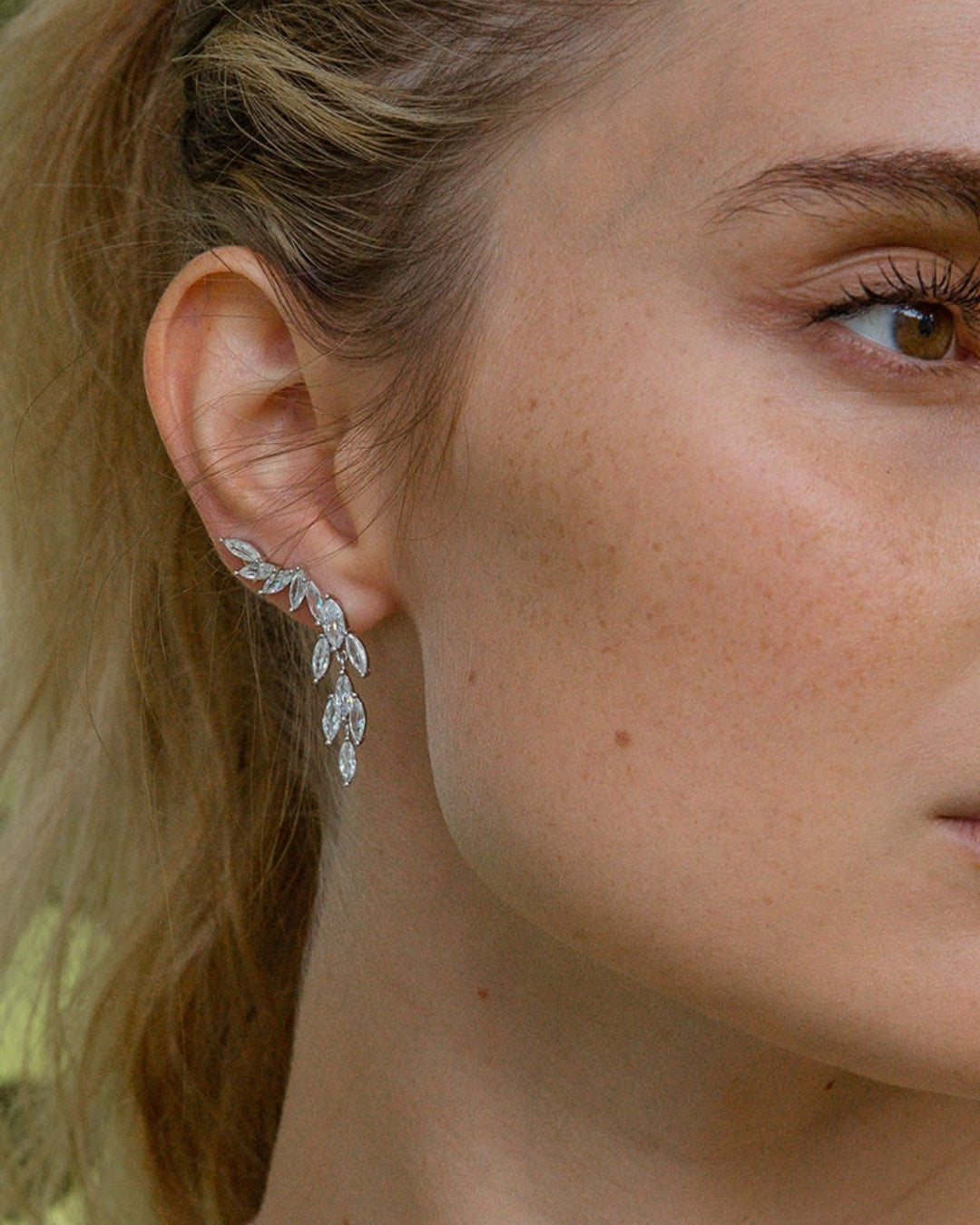 woman wearing a silver leaf-shaped earringI ARTSY SILVER 
